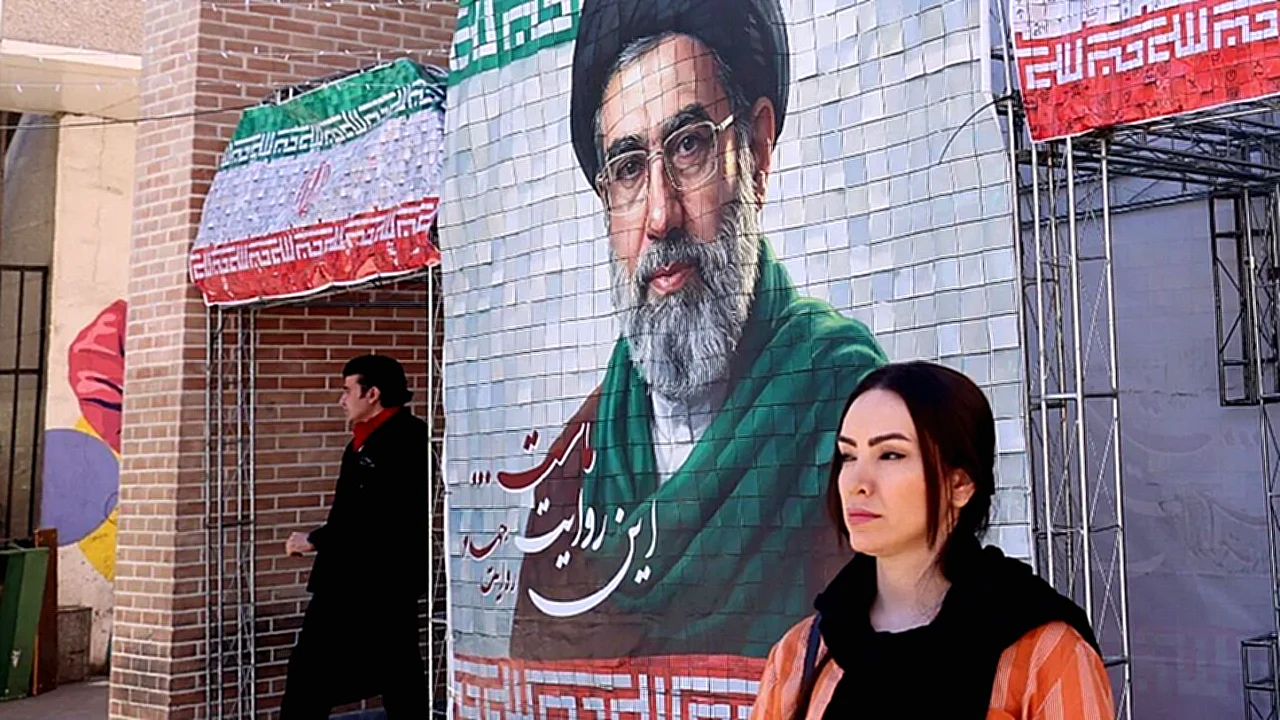 إيران ترد مقترح امرأة تمر بجانب صورة كبيرة لقائد إيران آية