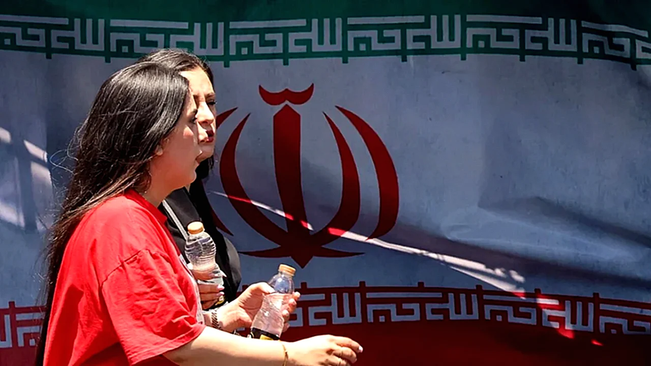 إيران والولايات المتحدة نساء يمشين أمام العلم الإيراني في