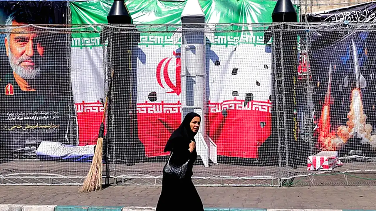 السي إيه إيران السي آي إيه - امرأة تمر بجانب نماذج لصواريخ