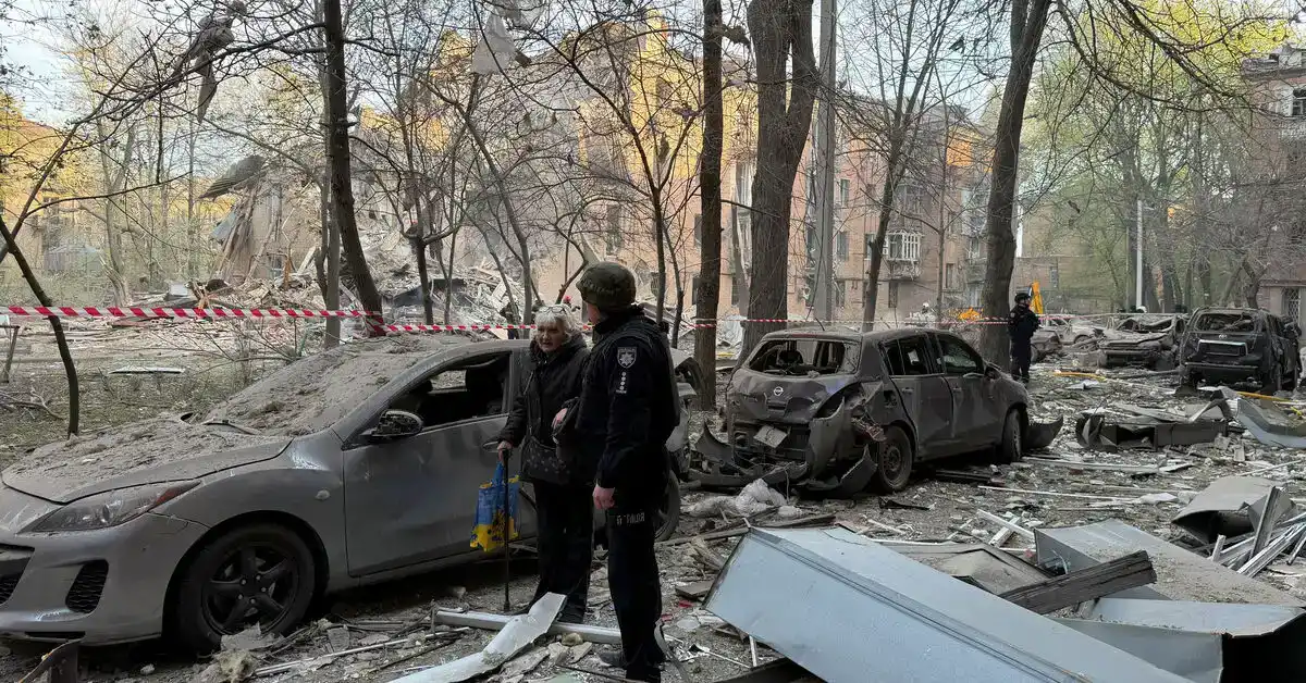 سكان يغادرون مبنى سكني دمرته طائرة مسيرة روسية في دنيبرو، خلال قصف دنيبرو